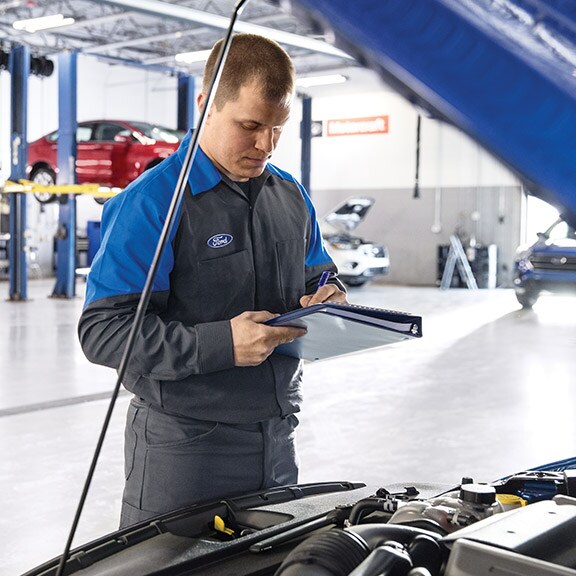  Technician in the service center checking a Ford battery