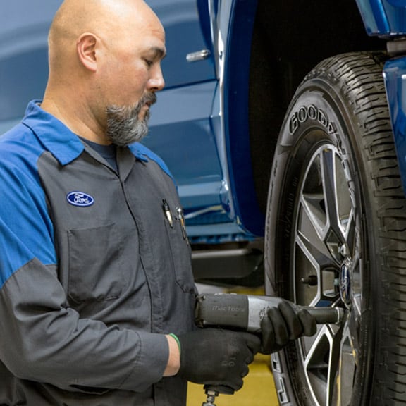  Ford technician putting on Ford tires
